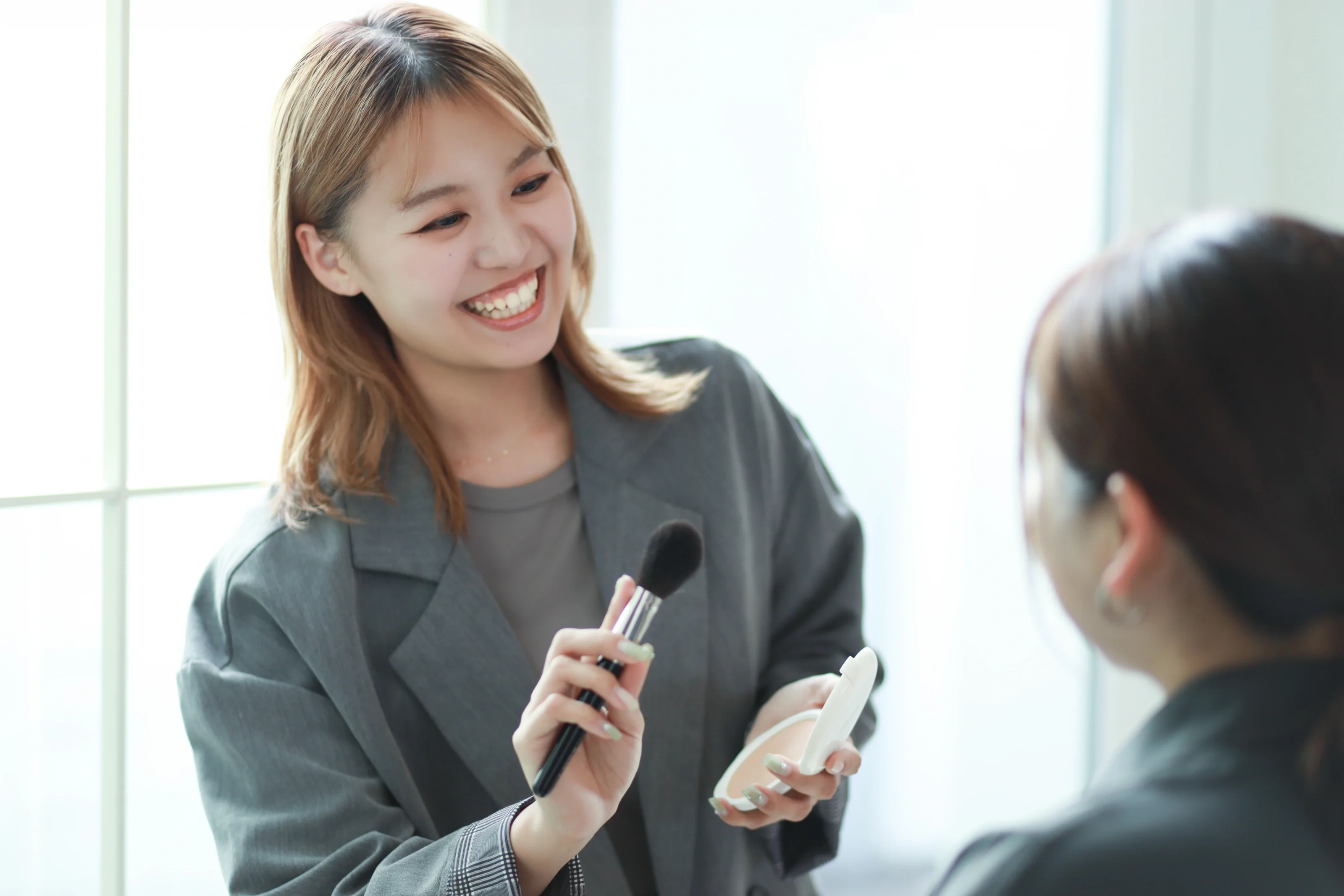 お客様と向き合いメイクをするスタイリスト