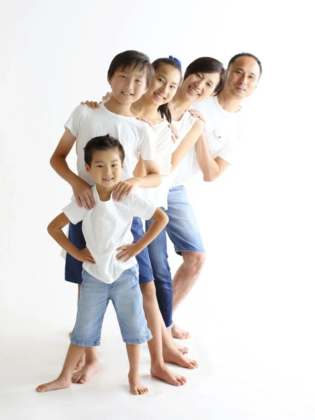 両親と三人の子どもが並んで笑う家族写真